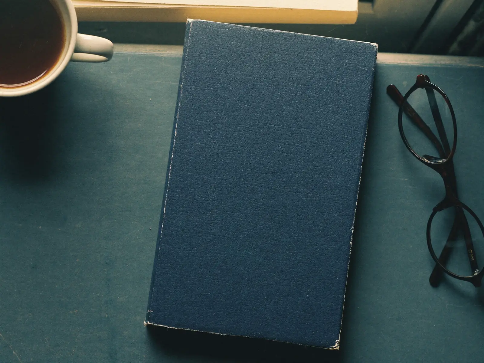 Documentos de trabalho e óculos de leitura sobre mesa de madeira